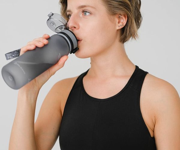 A calendar and a sports water bottle on a desk, symbolizing routine.