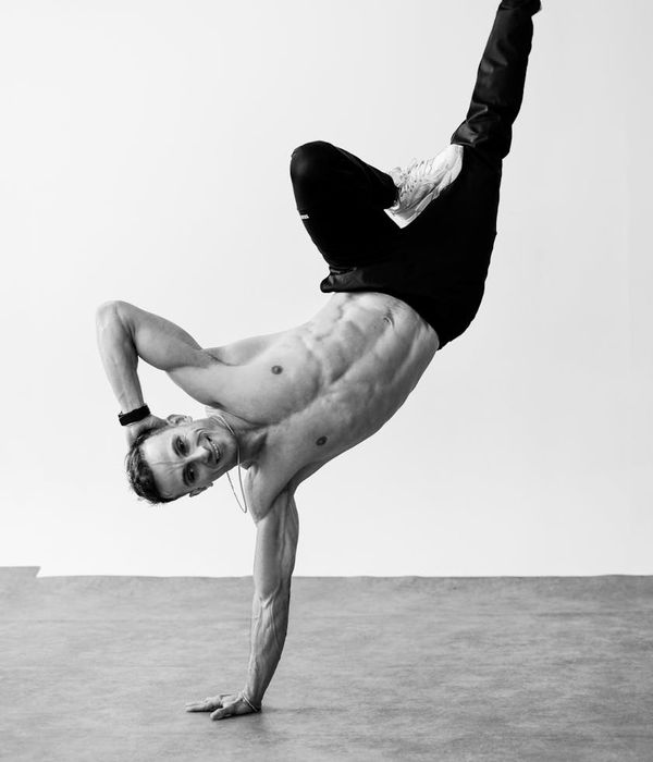Man performing a controlled strength exercise in a bright, modern studio.
